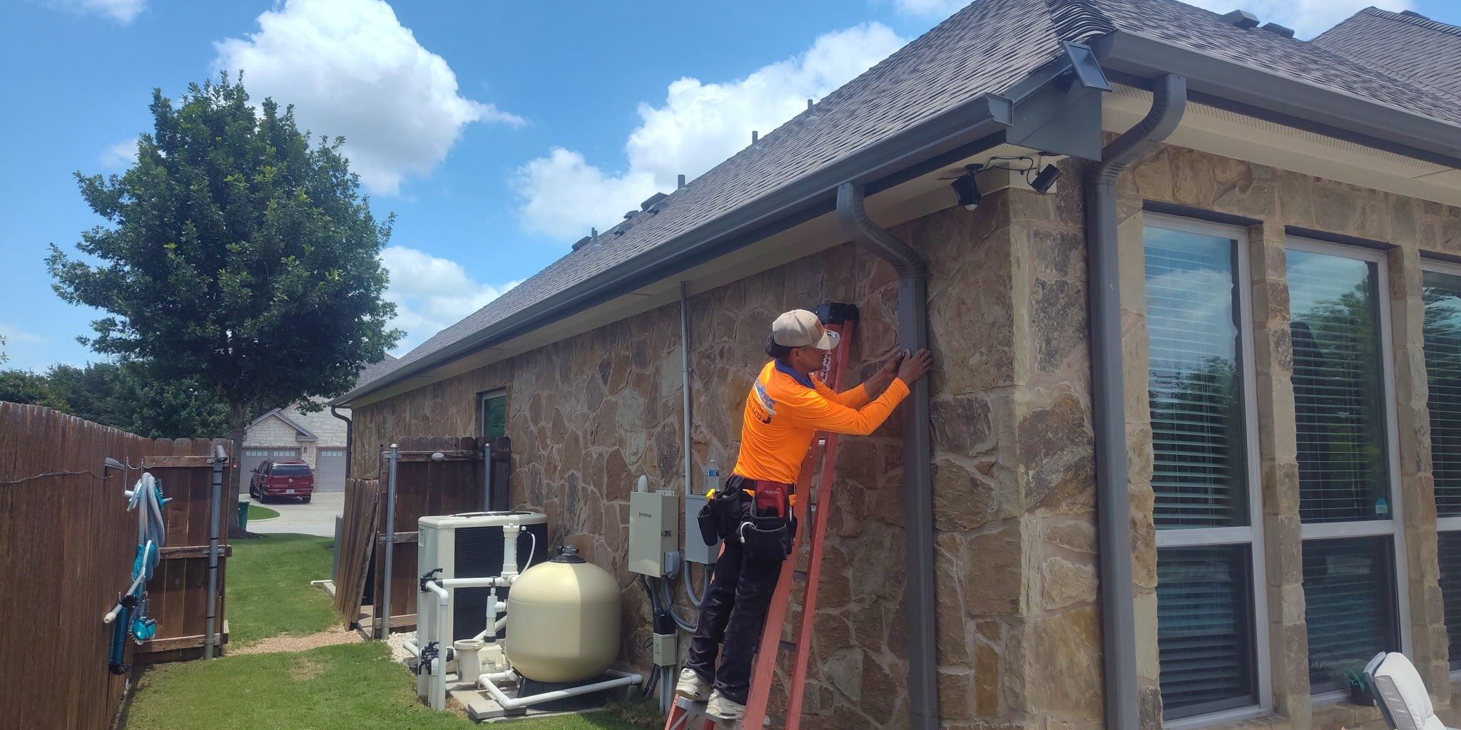 AquaWorks® Rain Gutters technician installing a custom downspout solution for a residential home.